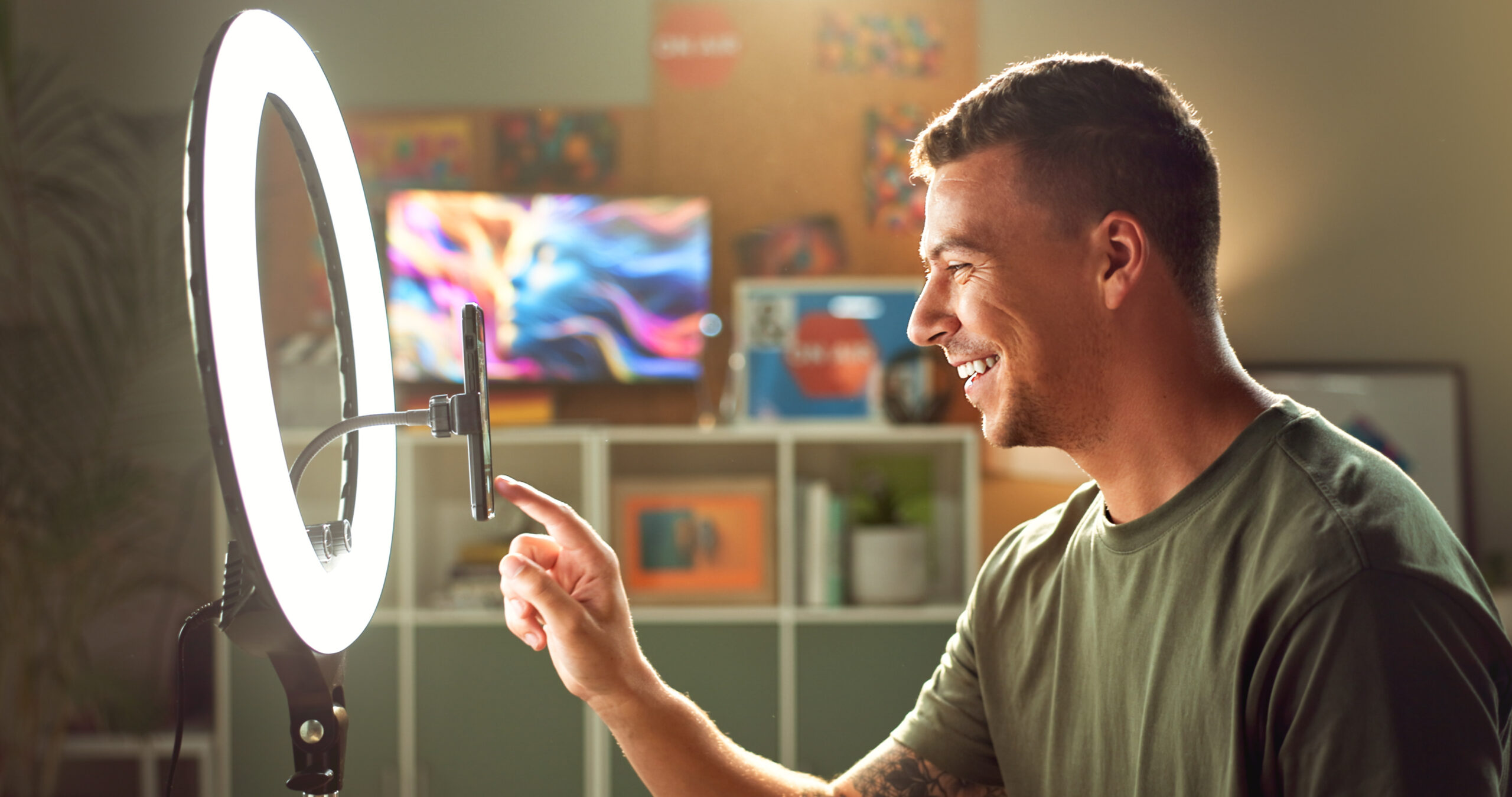 Founder led marketing being showcased with a man in a t-shirt in front of his phone and a light recording a video.